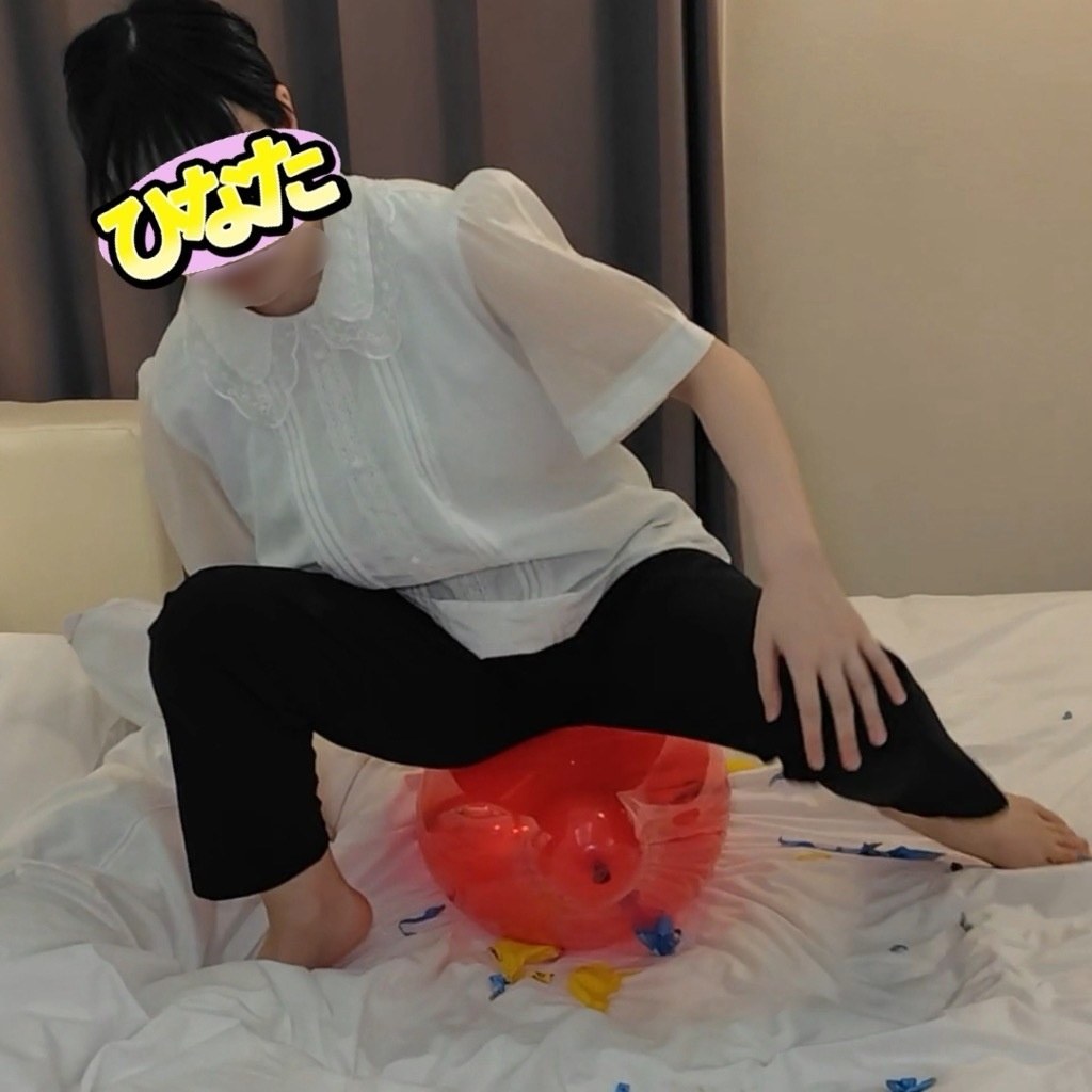 赤い風船の上に座って体重をかけるひなた