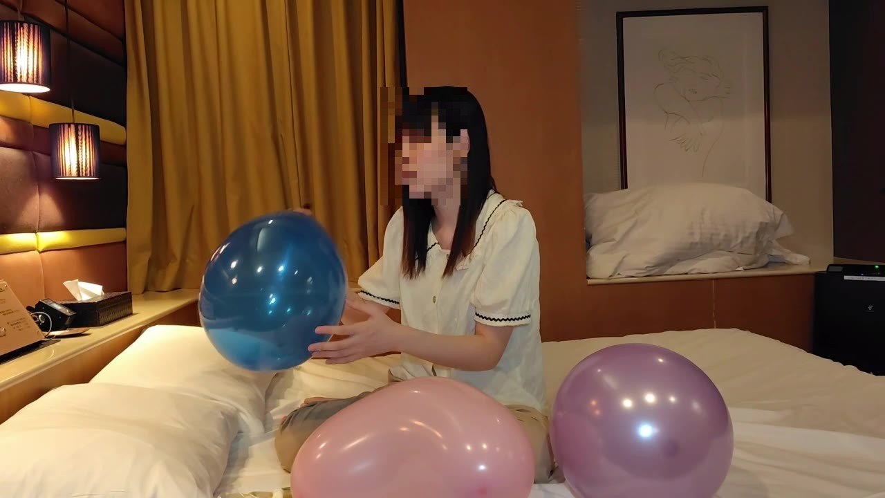 青い風船を両手で持ってふくらませるひなた