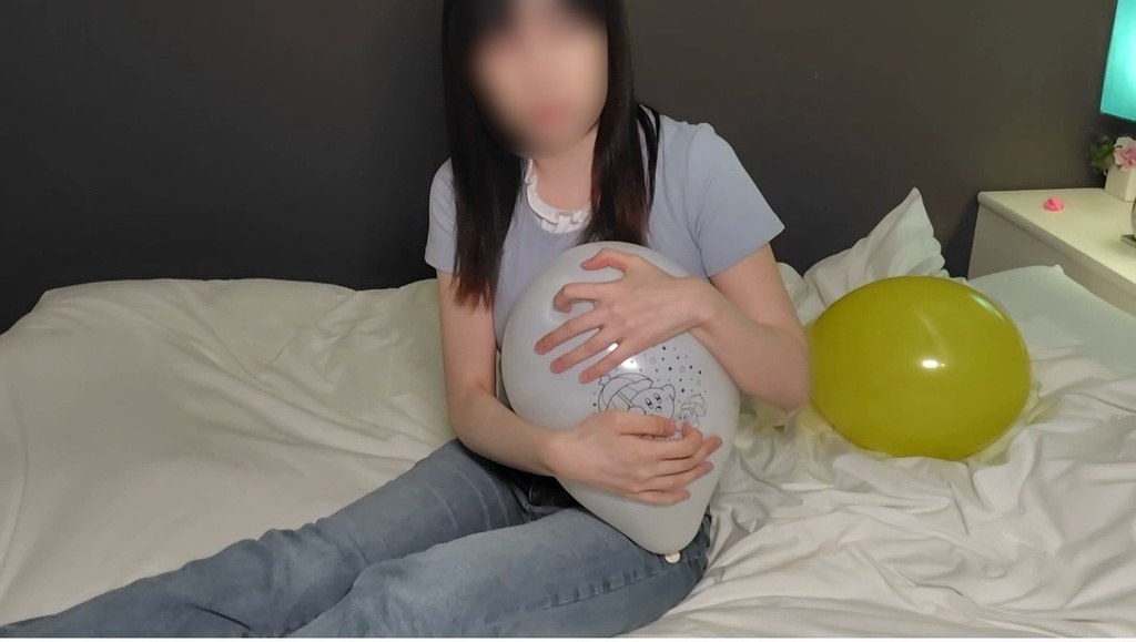 白い風船を抱えてベッドに座るひなた