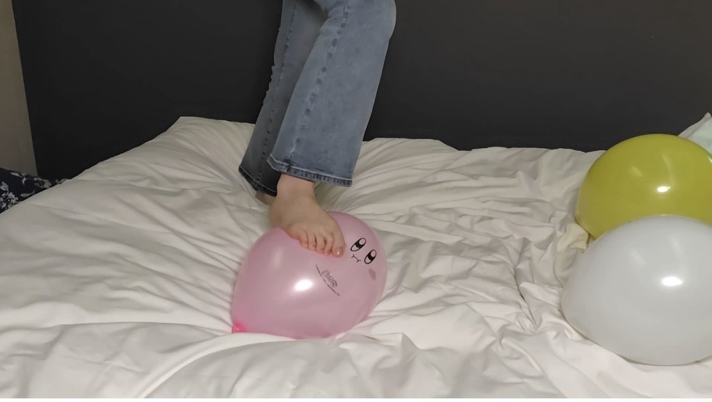 素足でピンクの風船を踏むひなたの足元
