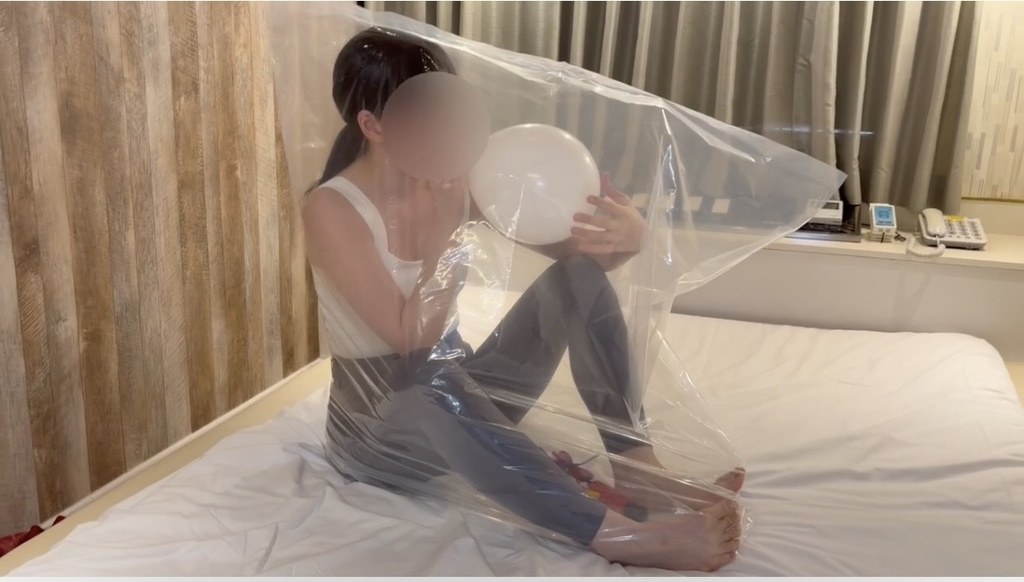 ビニール袋の中で白い風船をふくらませるひなた