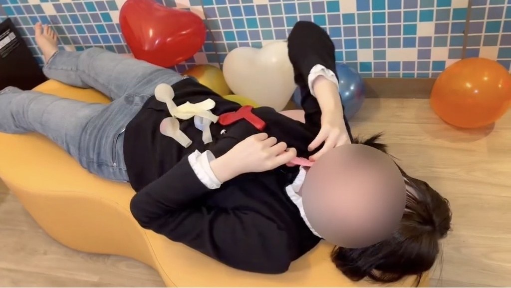 ふくらませた風船を体のまわりに置いて寝転ぶひなた