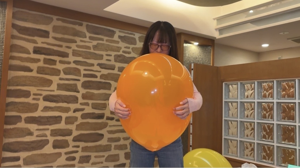 オレンジの風船を両手で持つ麻倉ミクさん