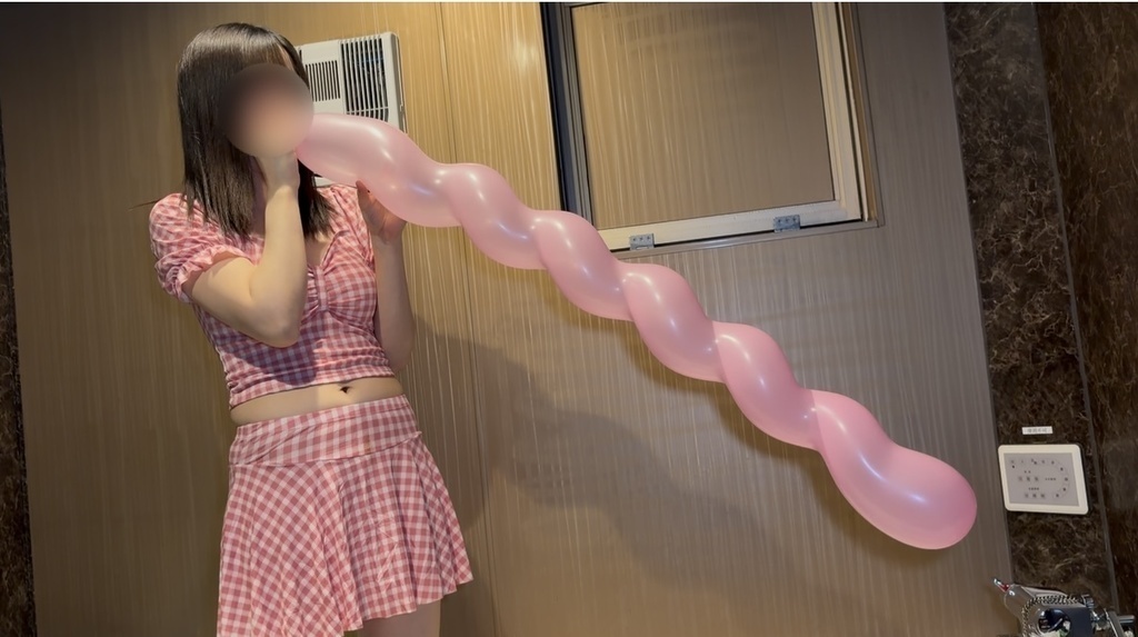 ピンクのスパイラルバルーンをふくらませるひなた