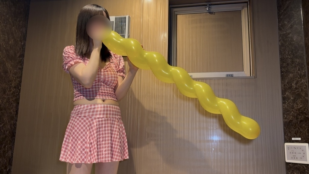 黄色いスパイラルバルーンをふくらませるひなた
