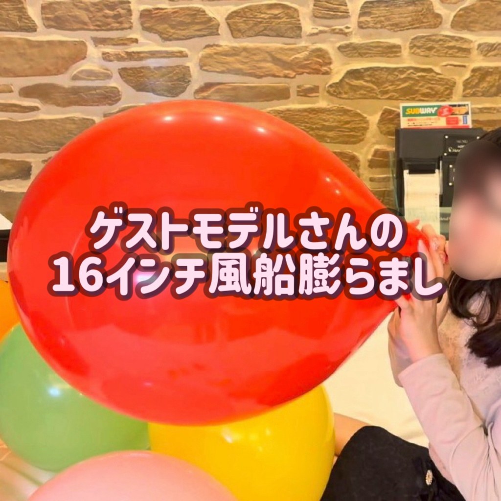 赤い16インチ風船をふくらませるゲストモデルBさん(タイトル入り)