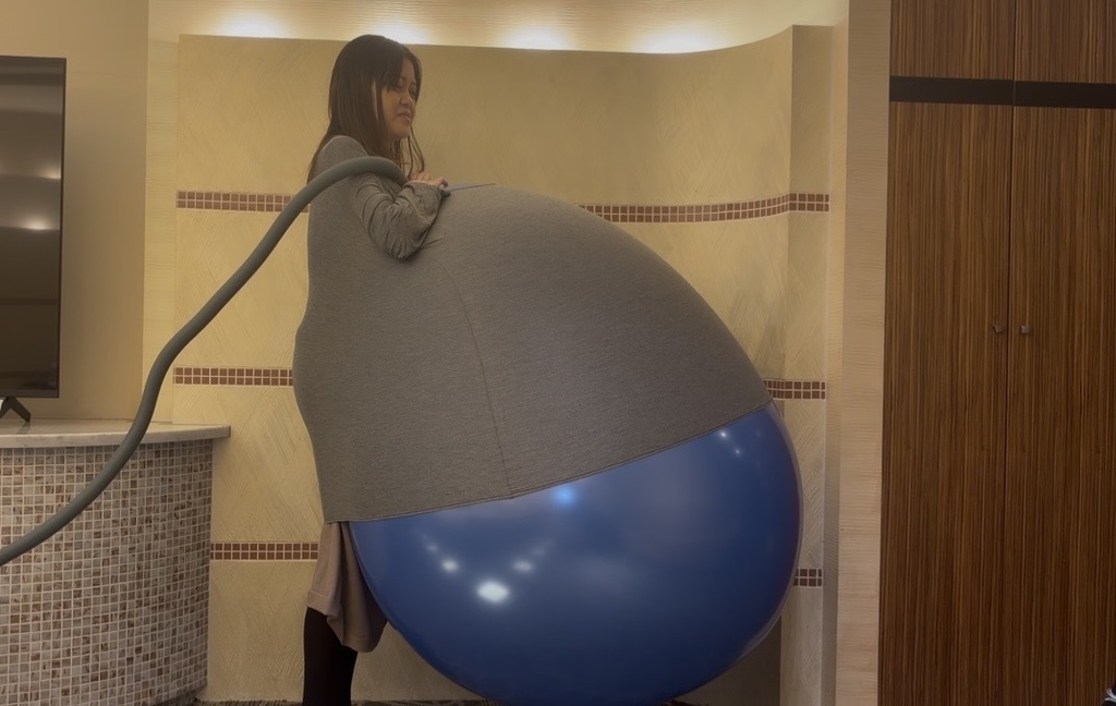 服の中で青い巨大風船が大きくふくらんだゲストモデルDさん