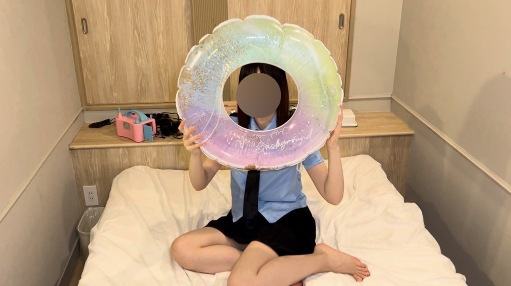 ふくらんだ浮き輪を顔の前に掲げるひなた