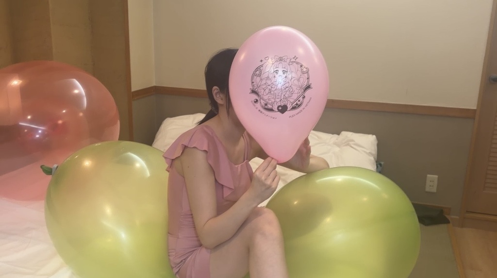 ピンクのキャラクター風船をふくらませるひなた