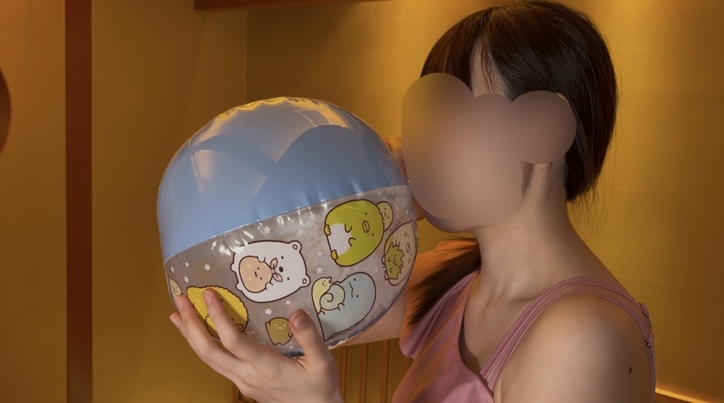 キャラクター柄のビーチボールをふくらませるひなたの横顔