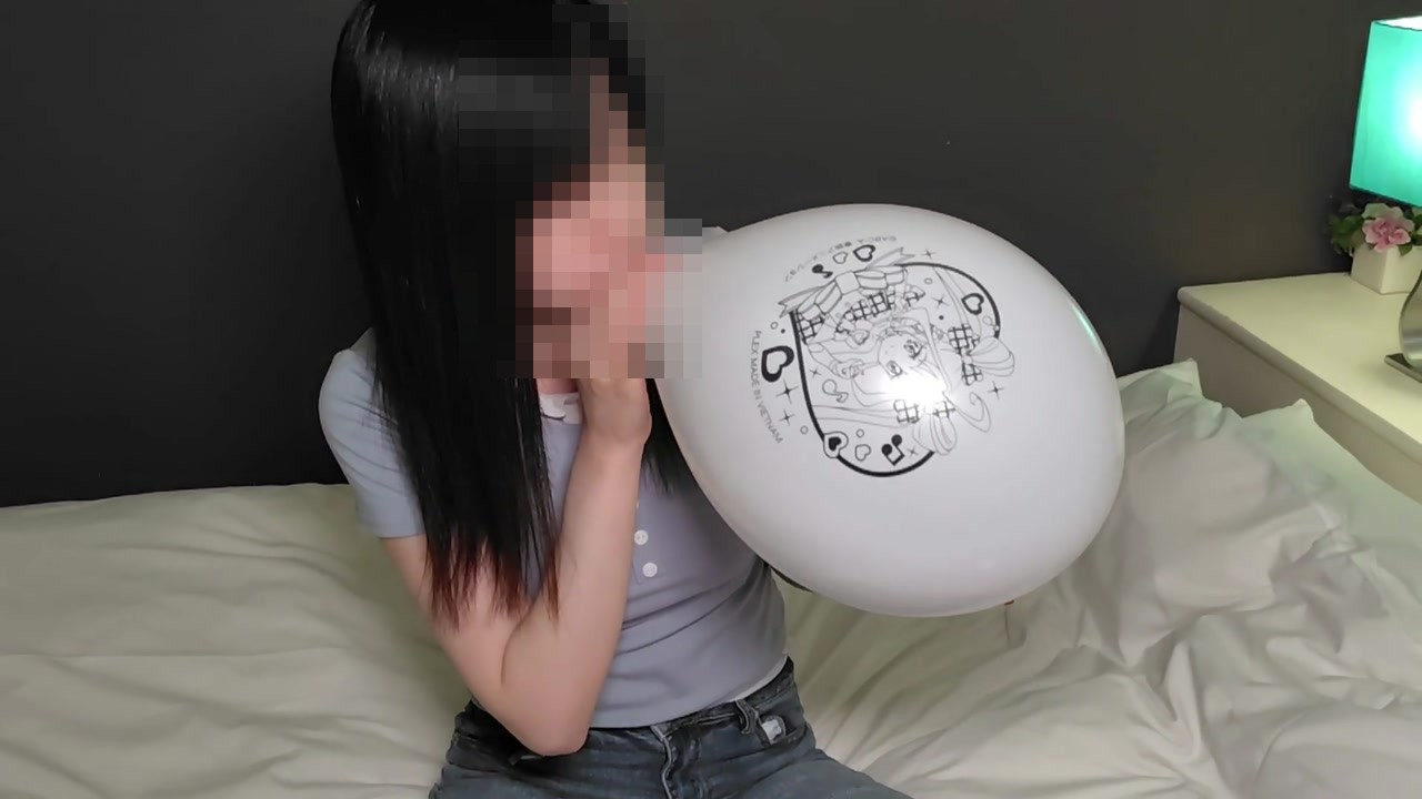 白いキャラクター柄の風船を大きくふくらませるひなた