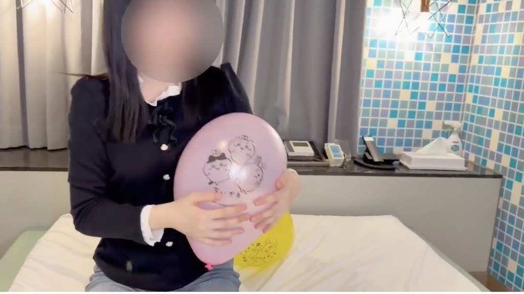 ピンクの風船を胸の前で抱きしめるひなた