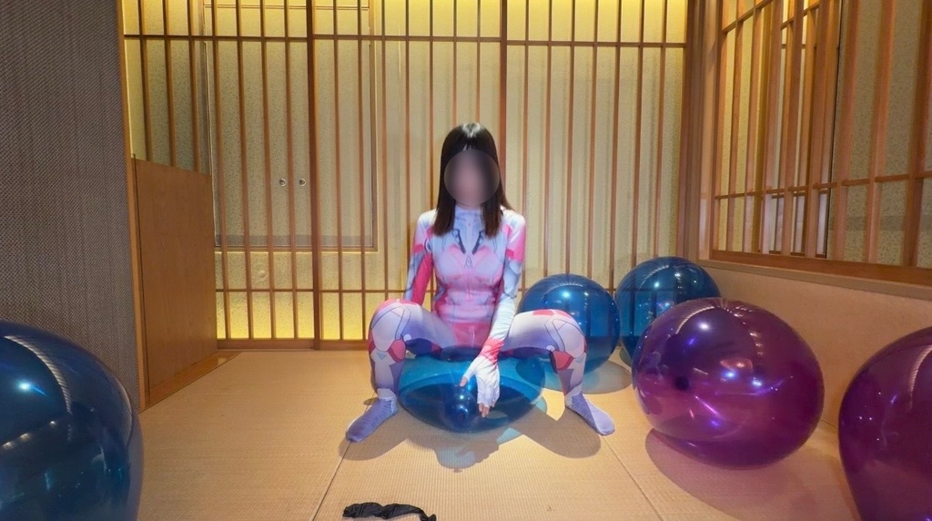青いクリスタル風船にしゃがんで体重をかけるひなた