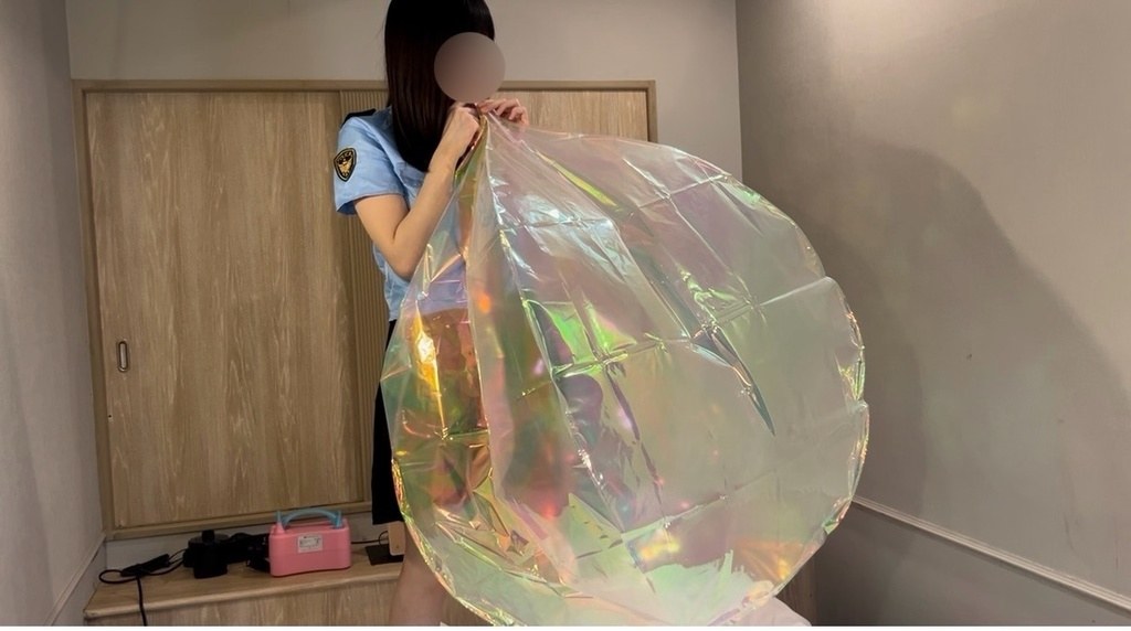 立ったまま大きなフィルムバルーンに息を吹き込むひなた