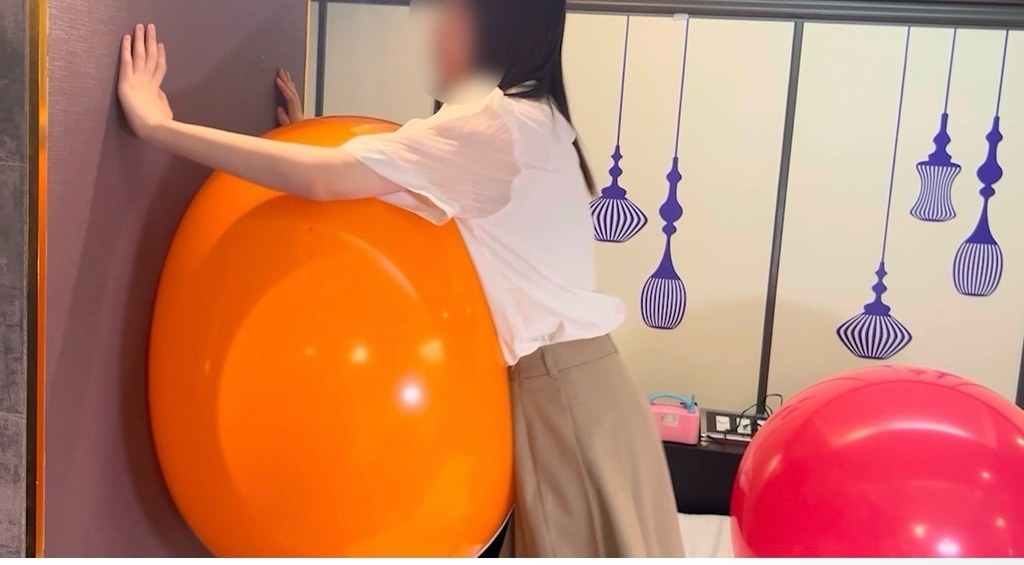 オレンジの巨大風船を壁に押しつけて抱きつくひなた