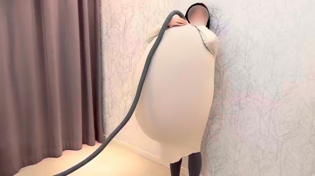 服の中で大きくふくらんだ巨大風船を抱えるひなた