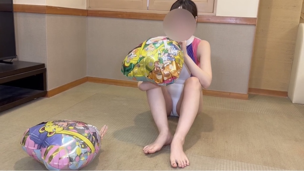 ハート形のマイラーバルーンをふくらませる競泳水着のひなた
