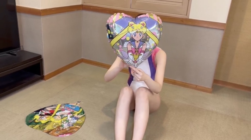 ハート形のマイラーバルーンを顔の前に掲げるひなた