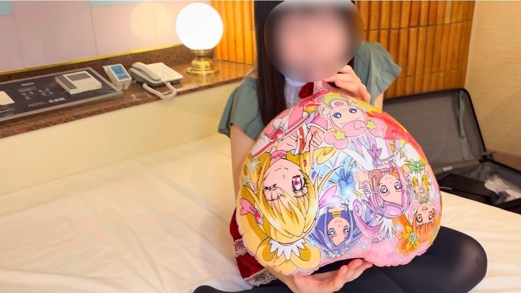 カラフルな柄のマイラーバルーンを胸に抱えてふくらませるひなた