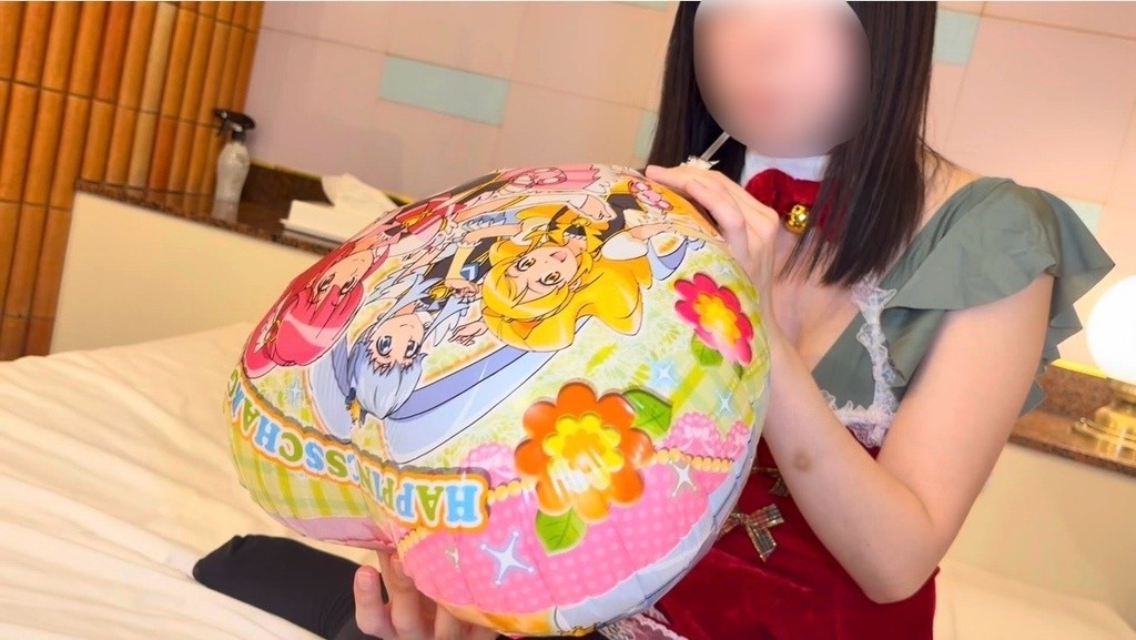 ふくらんだマイラーバルーンを両手で持つ赤いワンピースのひなた