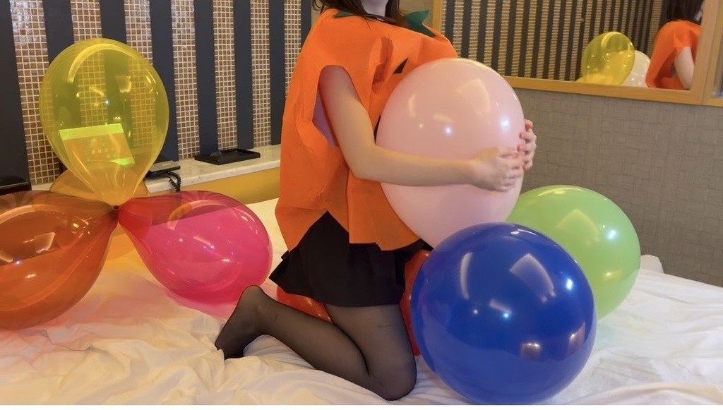 ピンクの風船を抱きしめるかぼちゃのコスプレのひなた
