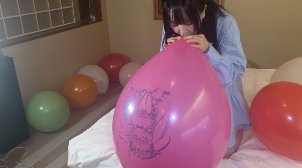 ピンクのイラスト風船を口で膨らませる望月みうなさん