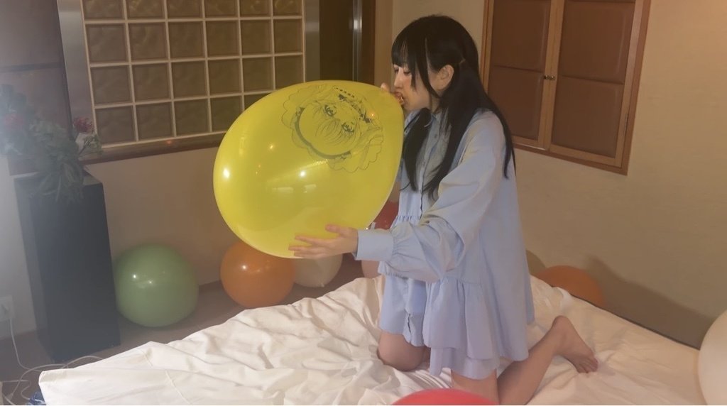 黄色いイラスト風船を膨らませる望月みうなさん