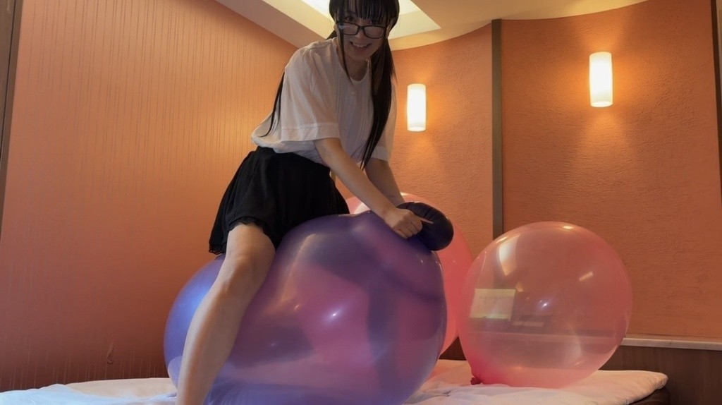 紫の大きな風船に座って弾む望月みうなさん