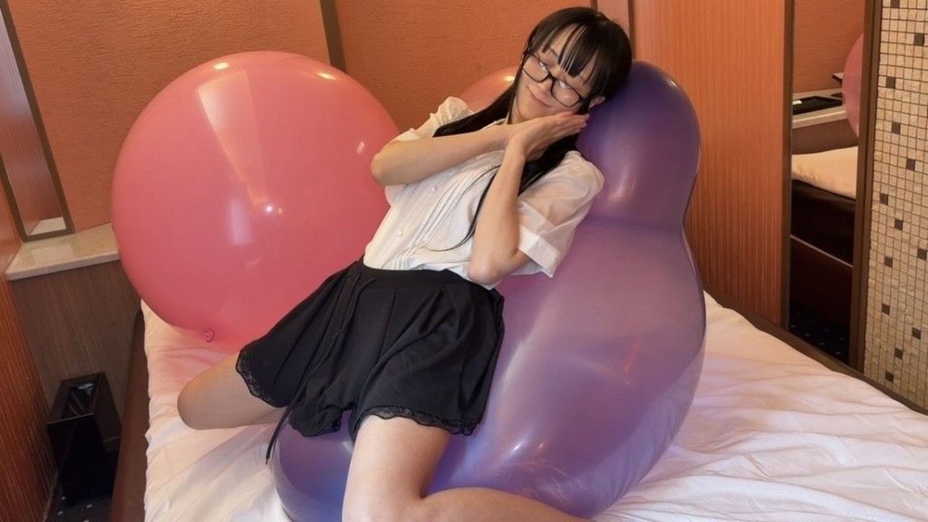 紫の大きな風船に体をあずけてポーズをとる望月みうなさん