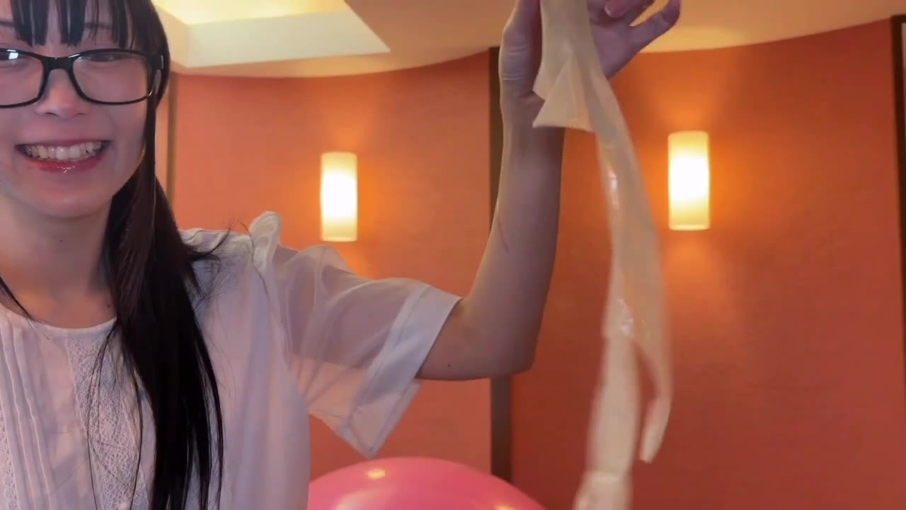 笑いながら割れた風船の破片を持ち上げる望月みうなさん