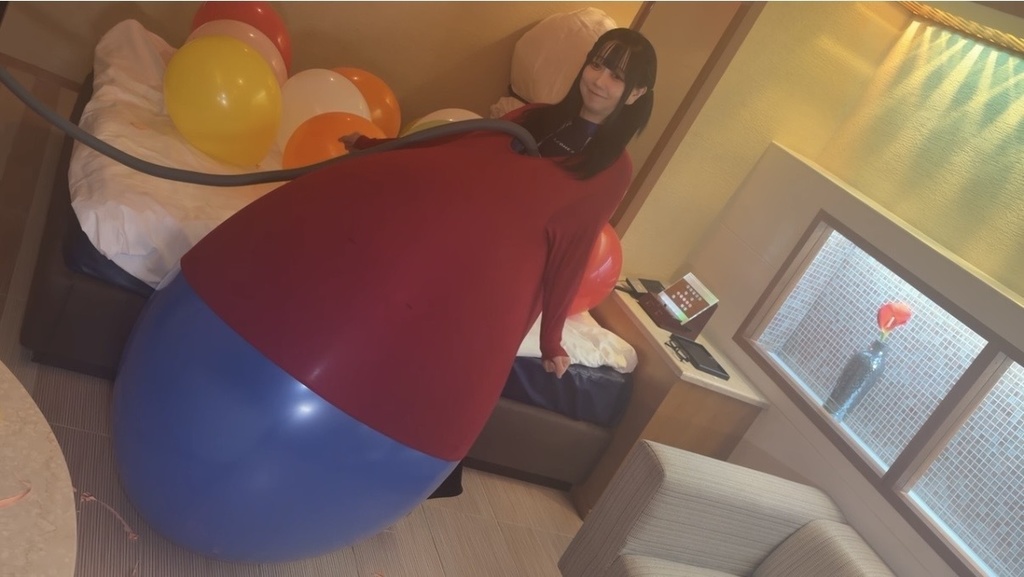 赤い服の中で青い巨大風船がふくらんでいく望月みうなさん