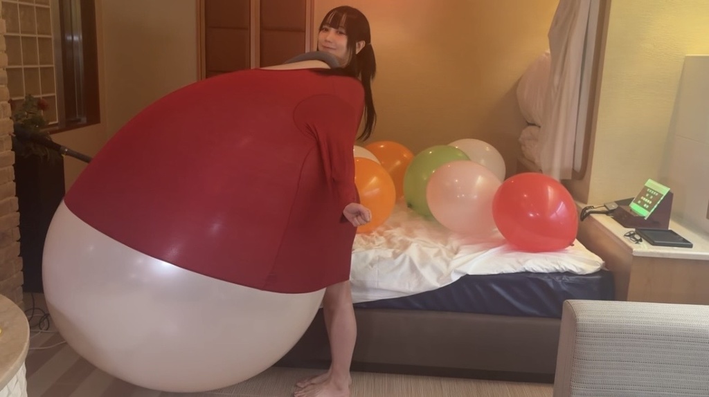 赤い服の中でパンパンにふくらんだ白い巨大風船と望月みうなさん