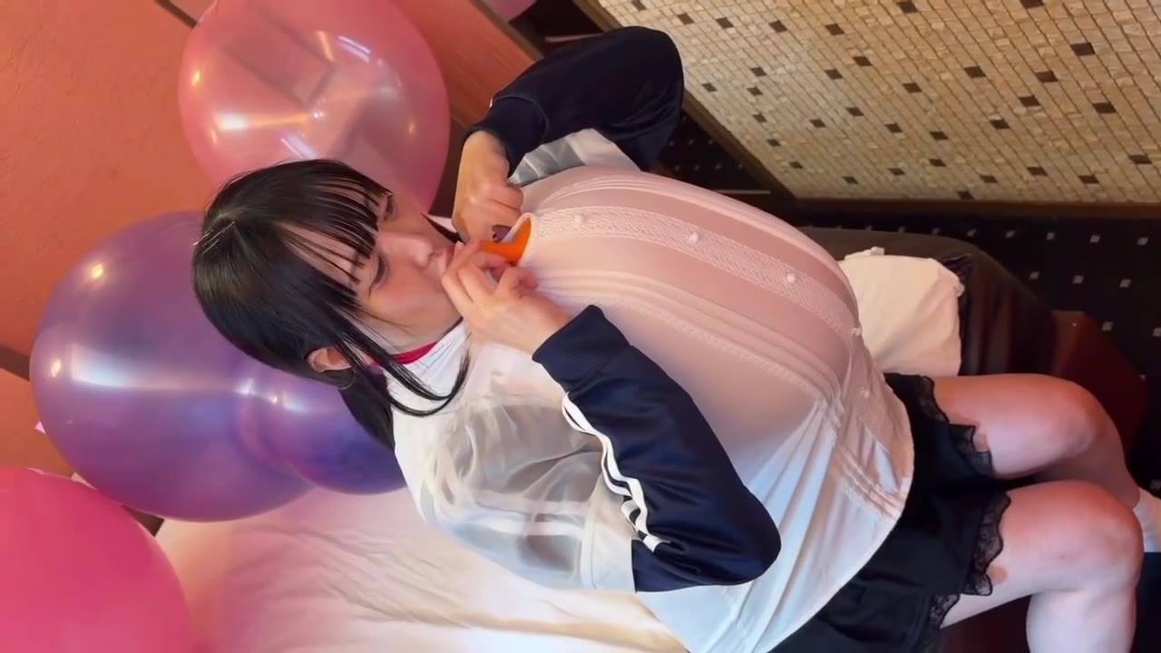 服の中の風船を抱えたまま、ベッドに寝そべってふくらませる望月みうなさん