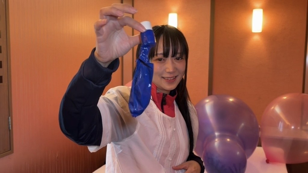 割れた青い風船を指でつまんで見せる望月みうなさん