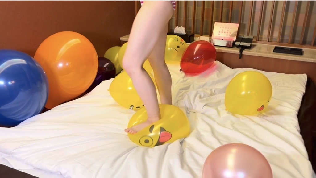 顔付きの風船を足で割ろうとする様子