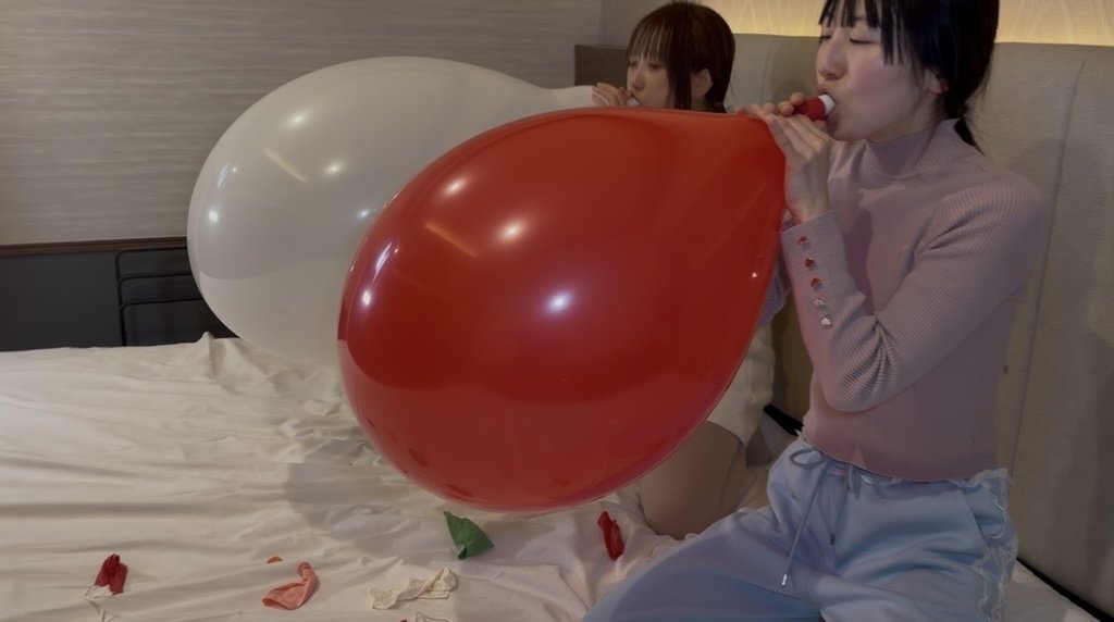2人並んで風船を膨らませる膨らまし割り対決