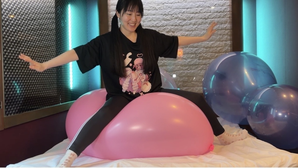 ピンクの巨大風船にまたがって両手を広げる夢姫しほさん