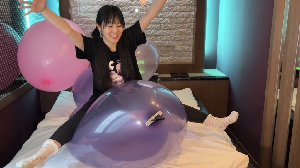 透明な紫の巨大風船にまたがってバランスをとる夢姫しほさん