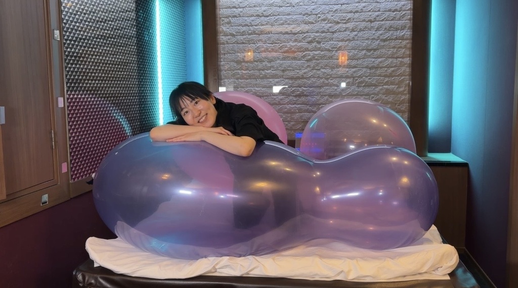 紫のひょうたん型巨大風船に寝そべってほほえむ夢姫しほさん