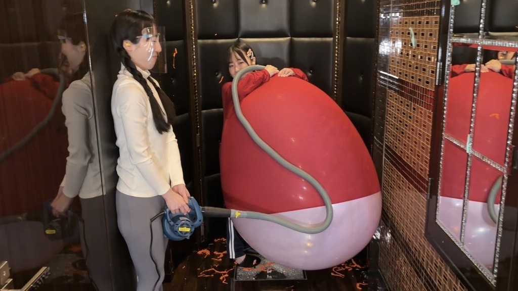 赤い服の中でパンパンにふくらんだピンクの巨大風船