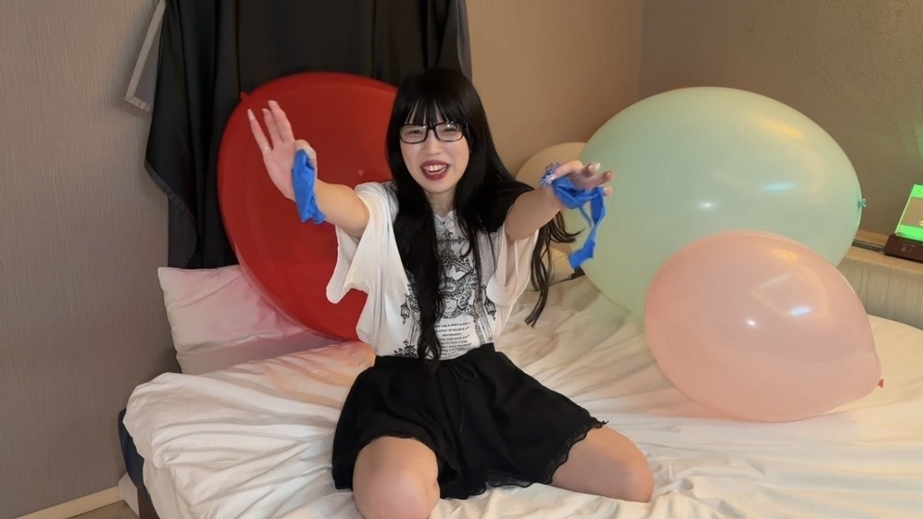 割れた青い風船の破片を両手で見せるゆりざべすさん